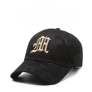 Detail of gold cursive embroidery on a black camouflage baseball cap fabric