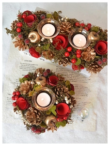 Top view of Christmas candle holders with red berries and golden pinecones on snow