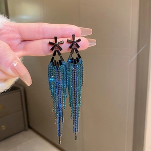 Detailed close-up of long tassel earrings with blue-green gradient rhinestones