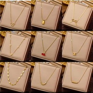 Macro detail of various 18K gold plated pendants including clover and bow designs