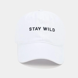 Detail of Stay Wild black embroidery on a white cotton baseball cap with twill texture
