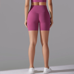 Detail view of high-waisted yoga shorts in dark pink with seamless butt lifting design