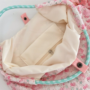 Detail shot of the pink floral tote interior with cream lining and a secure zipper pocket