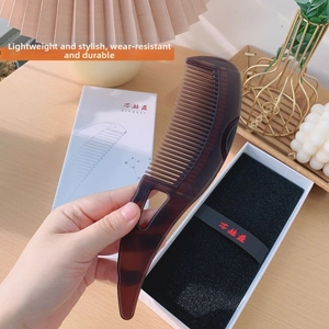 Macro detail of tortoiseshell massager comb with gift box and elegant packaging
