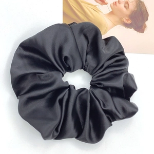 Nahaufnahme eines schwarzen Satin-Haargummis mit glänzendem Finish und Textur