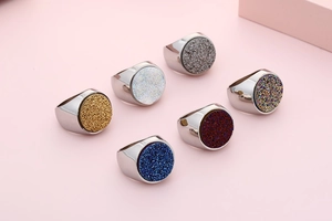 Top view of six stainless steel signet rings with colorful shimmering crystal inlay