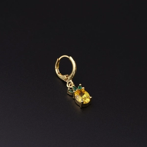 Golden pineapple huggie earring with yellow and green zircon stones on black background