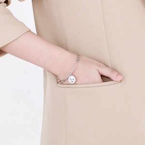 Chic silver titanium steel bracelet featuring a playful winking smiley face charm for women