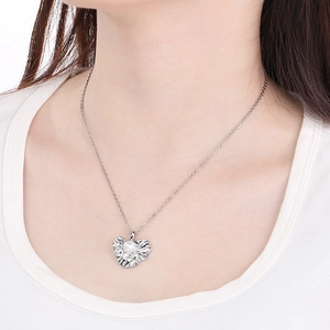 Close-up of heart-shaped wrinkled texture necklace with pearl inlay on model's neck