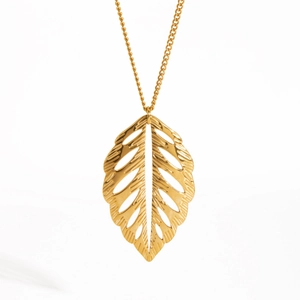 Élégant collier avec pendentif feuille évidée en or et acier inoxydable sur blanc