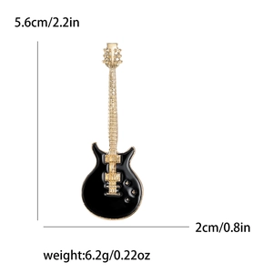 Detailed dimensions of the black and gold guitar brooch, 5.6cm by 2.0cm, weighing 6.2g