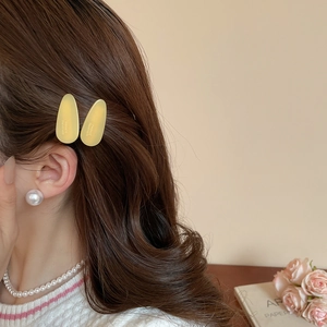 Détail de pinces à cheveux gouttes jaunes avec inscription France Handmade sur modèle
