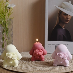 Detailed close-up of rabbit-shaped scented candles with rose bouquets on a woven mat