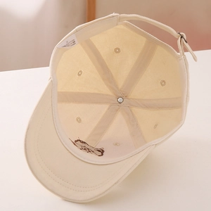 Detail view of cotton baseball cap interior showing seams, stitching, and metal buckle
