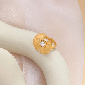 Close-up of golden sunburst ring with white pearl and adjustable open band design