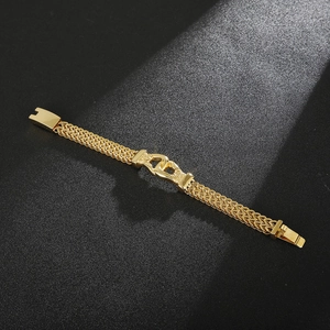 Close-up of gold-plated woven bone chain bracelet with U-shaped interlocking clasp