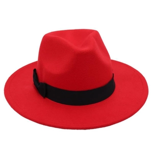 Detail of red wool fedora hat featuring a classic black ribbon bow on white background