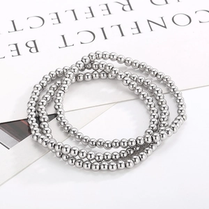 Close-up of three-piece silver beaded stretch bracelets with polished mirror finish