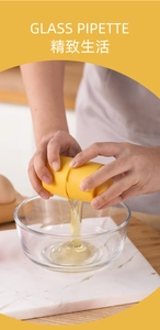 Detail of a yellow egg separator pouring egg white into a glass bowl in a kitchen