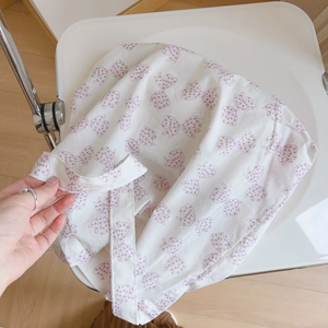 Détail d'un sac en coton blanc avec motifs nœuds violets et texture douce