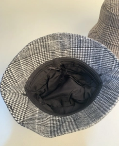 Internal detail of plaid wool bucket hat showing black lining and adjustable drawstring