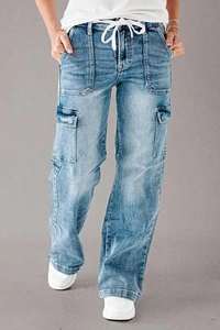 Detail of light blue washed denim cargo pants with drawstring waist and utility side pockets