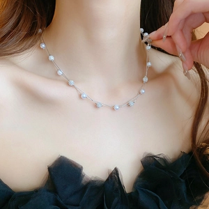 Detail view of double-layer silver chain necklace with pearls and crystal balls on skin