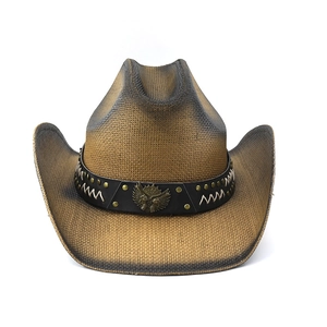 Detail of woven straw cowboy hat featuring brown gradient finish and eagle metal emblem