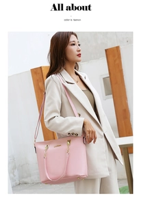 Close-up of pink tote bag with metal chain strap and luxury hardware on beige suit
