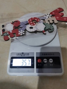 Detailed view of Nordic Christmas wooden gnome ornament weighing 35.7g on a digital scale