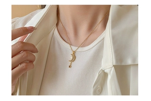 Golden moon and star tassel necklace worn by model showing its elegant hanging effect