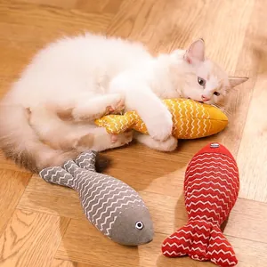 Katze kaut auf gelbem Katzenminze-Fisch Spielzeug zur Zahnpflege auf Holzboden