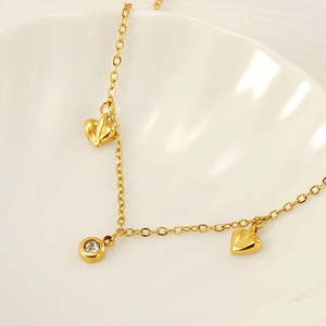 Close-up of titanium steel double-layered gold anklet with leaf and zircon charms