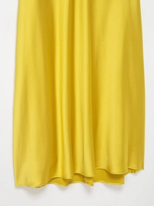 Vue détaillée du tissu en satin jaune gingembre montrant texture soyeuse et drapé élégant