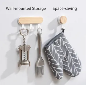 Minimalist wooden wall-mounted coat hooks with three hooks and one round peg on white wall