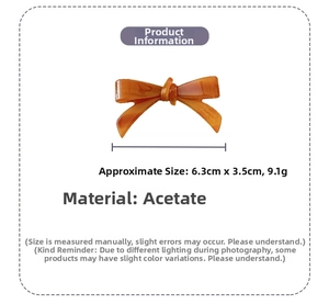 Detail view of amber acetate bow hair clip with dimensions 6.3cm by 3.5cm