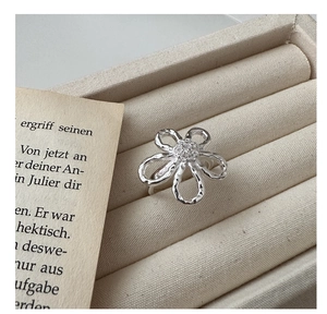 Macro shot of a floral silver ring with cubic zirconia center in a jewelry box