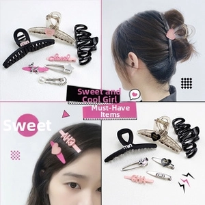 Détail de pinces à cheveux en cœur et griffes en résine noire, rose et marron