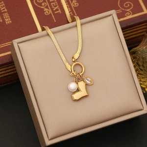 Detail of gold snake chain necklace with pearl and marquise crystal pendants on display