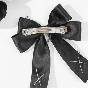 Detail of black satin bow hair clip with silver X metal charms and Paris engraved clip