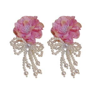 Pink floral fabric earrings with pearls and long tassel butterfly bow on white backdrop