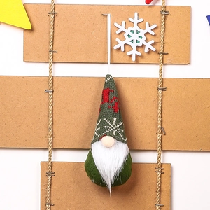 Detail of a Christmas gnome ornament featuring a green knitted hat with a red reindeer pattern