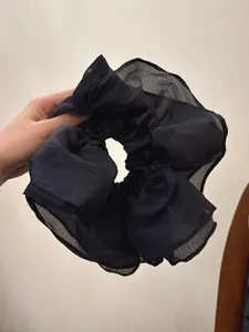 Detailed view of oversized black mesh scrunchie with layered pleats for hair styling