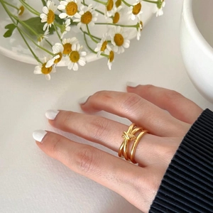Detail of a minimalist gold knotted ring worn by a model in a natural daylight setting