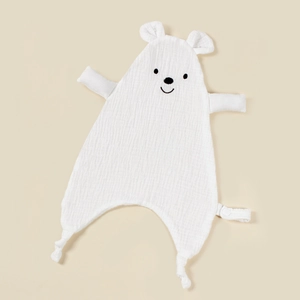 Detail of white cotton muslin baby security blanket with embroidered bear face and soft knots