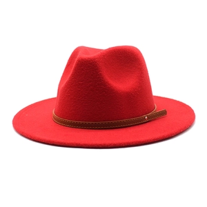Detail of red fedora hat with brown leather belt and silver metal rivet on brim
