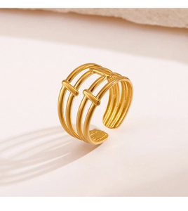 Detail of gold layered open ring showing geometric minimalist design on warm background