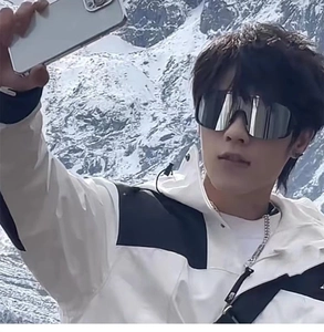 Close-up of oversized silver mirrored cycling sunglasses with snow mountain background