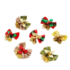 Detail view of festive Christmas bows with bells, holly leaves, and red berries decor