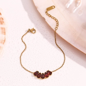 Detail of 18K gold-plated chain with five water-drop shaped red garnets and K18 hallmark
